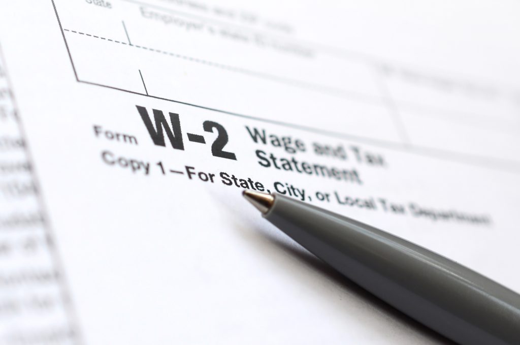 The pen lies on the tax form W-2 Wage and Tax Statement.